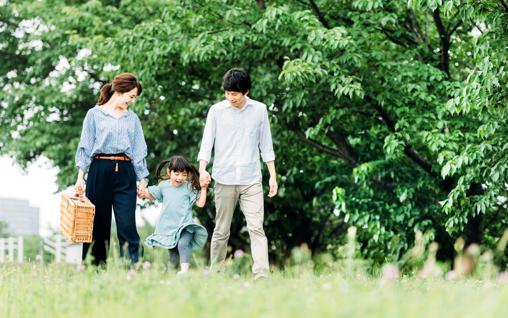 自然豊かな公園を散歩する親子