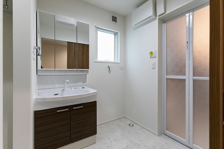 洗面台には三面鏡を採用。毎日使う洗面台だからこそ必要な物だけをスッキリと配置し、朝の支度や帰宅後の着替えもスムーズに行えるよう工夫しています