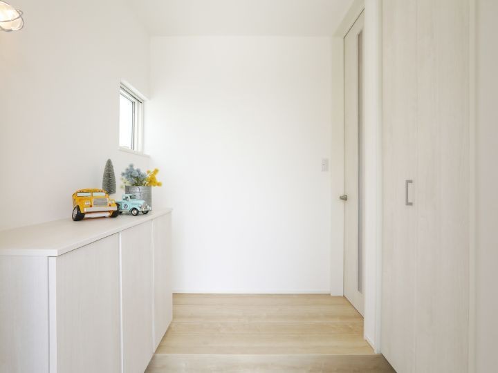2.5帖の白くて明るい玄関。シューズクロークにはベビーカーも収納でき、スッキリとした空間を保てる。