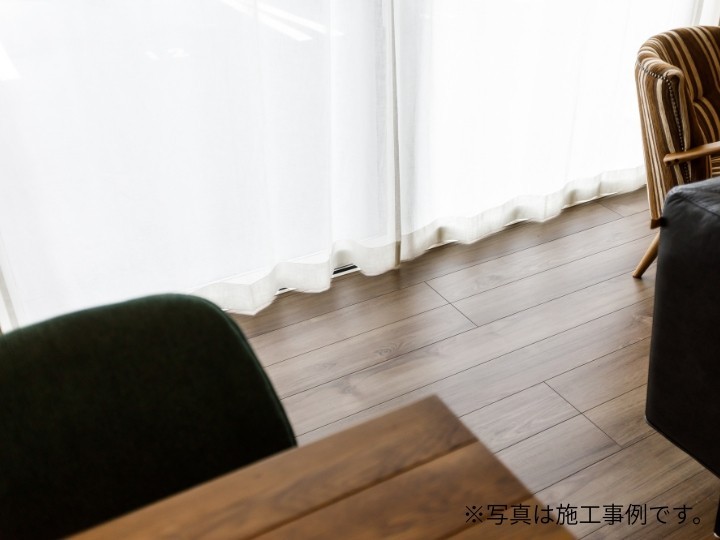 間接照明と突き板床が彩る約20帖のLDK。スリット格子で繋がるタタミコーナーが、家族の気配を感じさせつつ奥行きある開放的な空間を演出します。